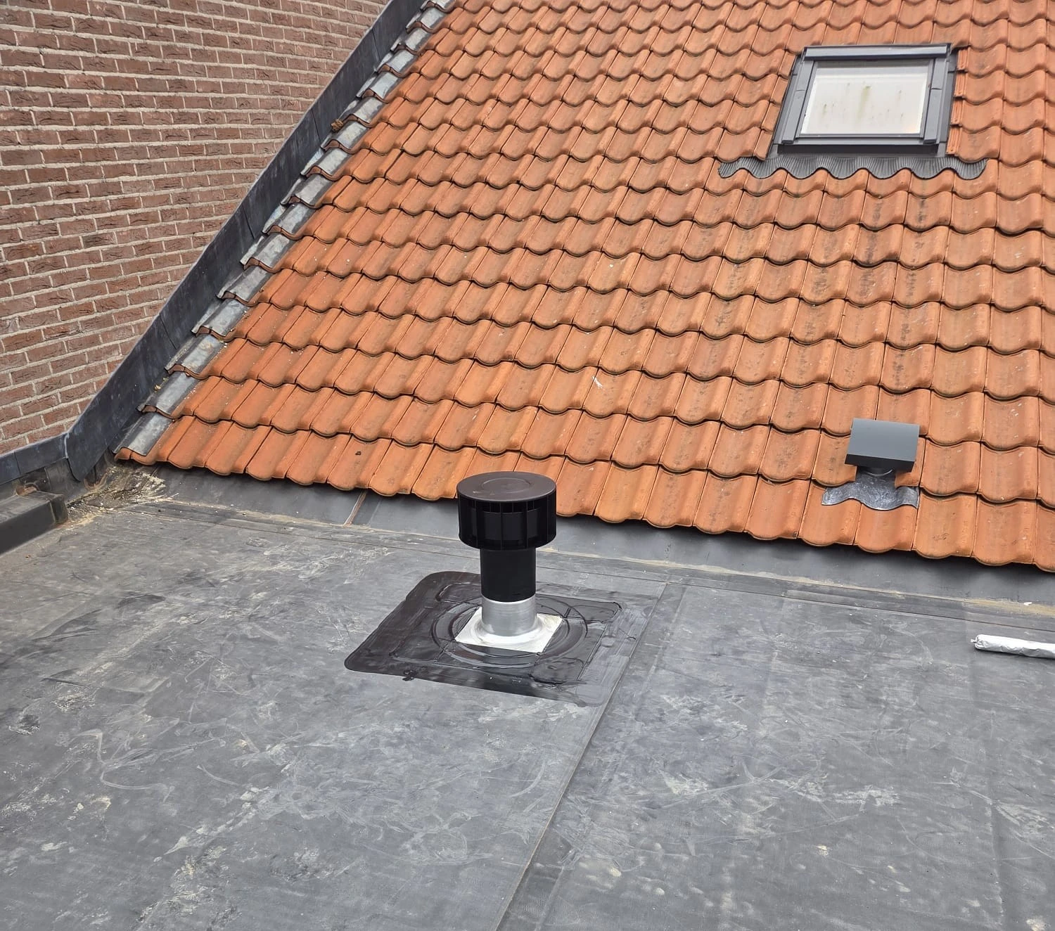 Een camionette met het logo van Dakwerken Desmet Branko voor een huis